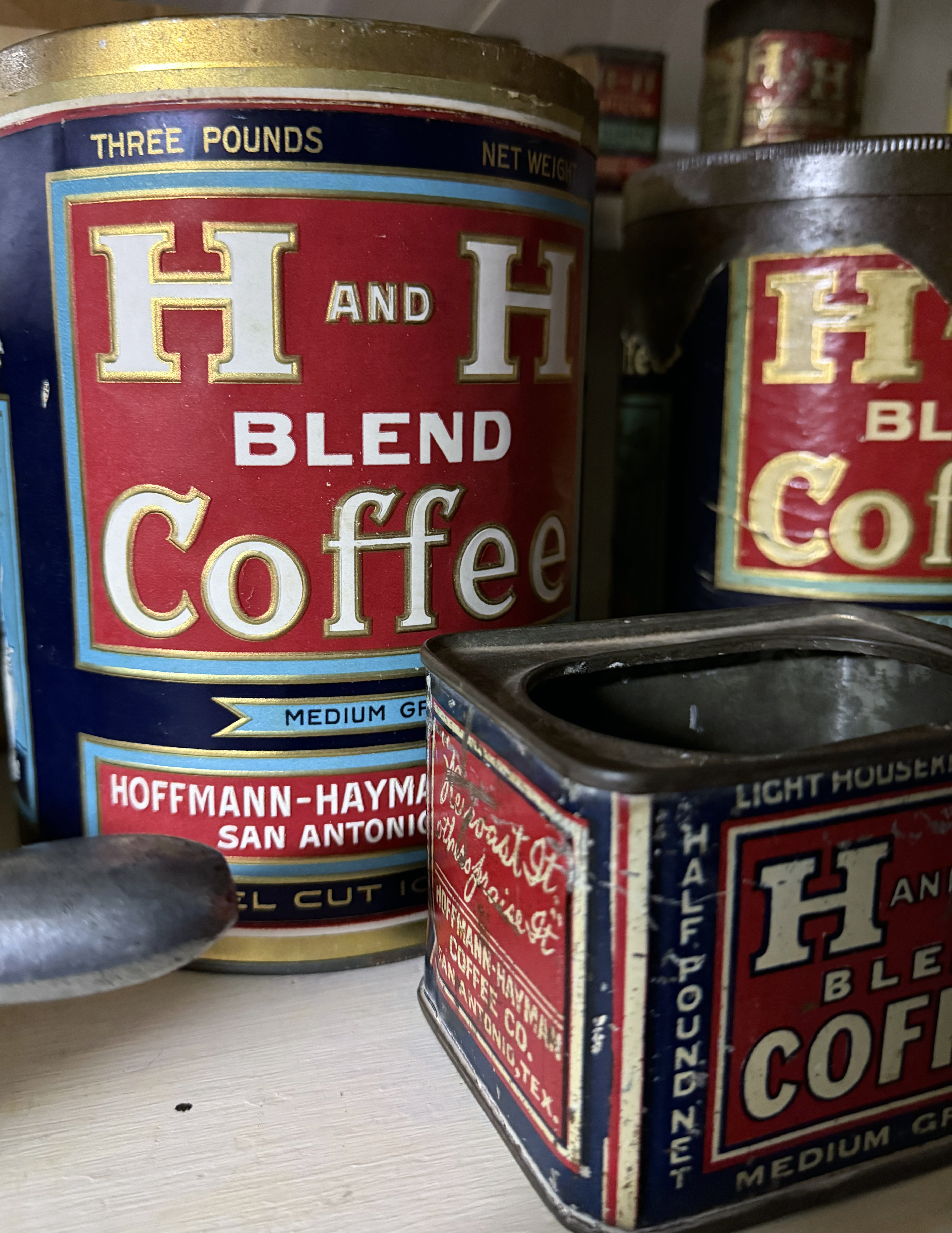 Close-up of H and H Blend Coffee tins, including a three-pound can and a Light Housekeepers half-pound