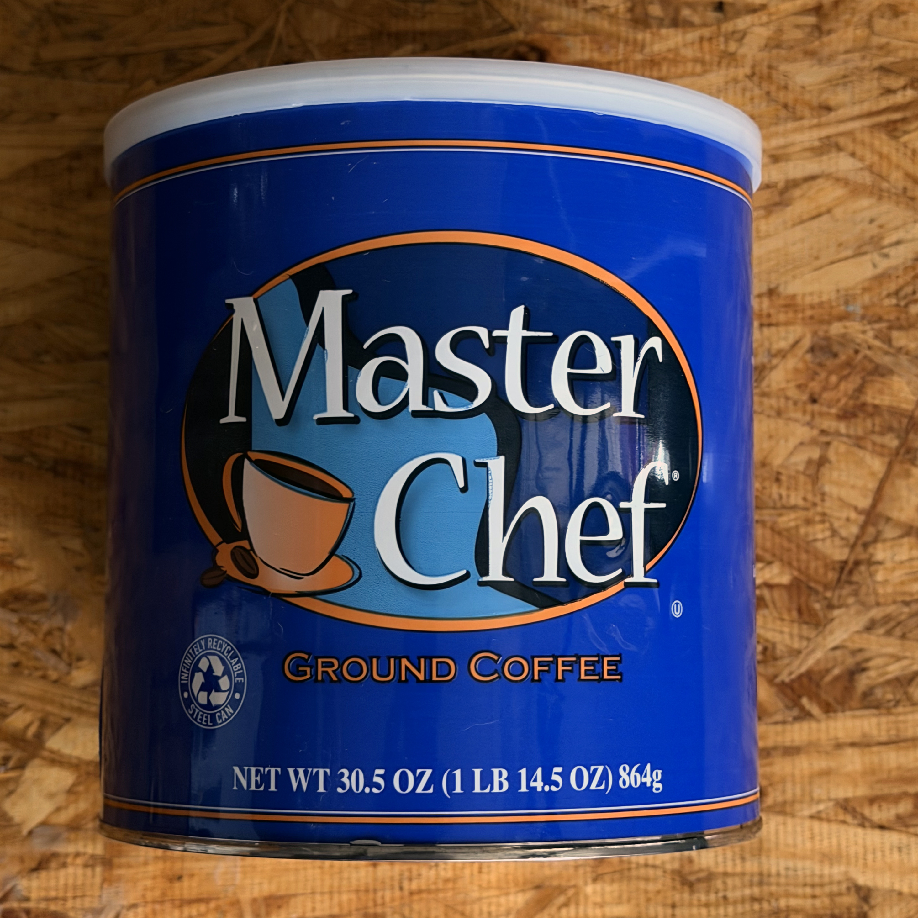 Master Chef Ground Coffee 30.5 oz cobalt blue steel can, Massimo Zanetti Beverage USA current production, orange-outlined oval wordmark with coffee cup and beans device, white plastic overcap, photographed 2026-07-14