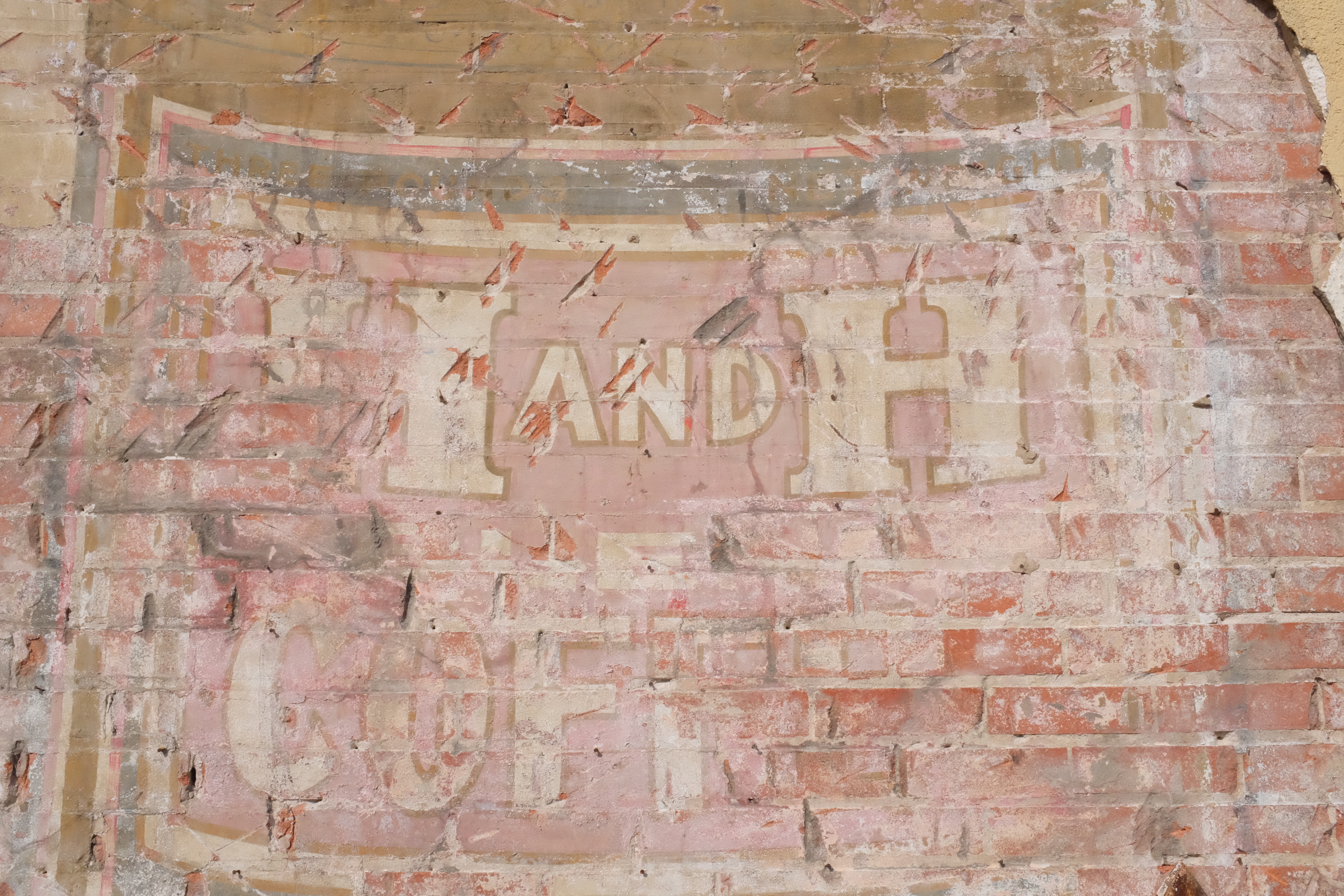 H AND H / COFFEE block lettering with decorative border; pecked brick for later stucco