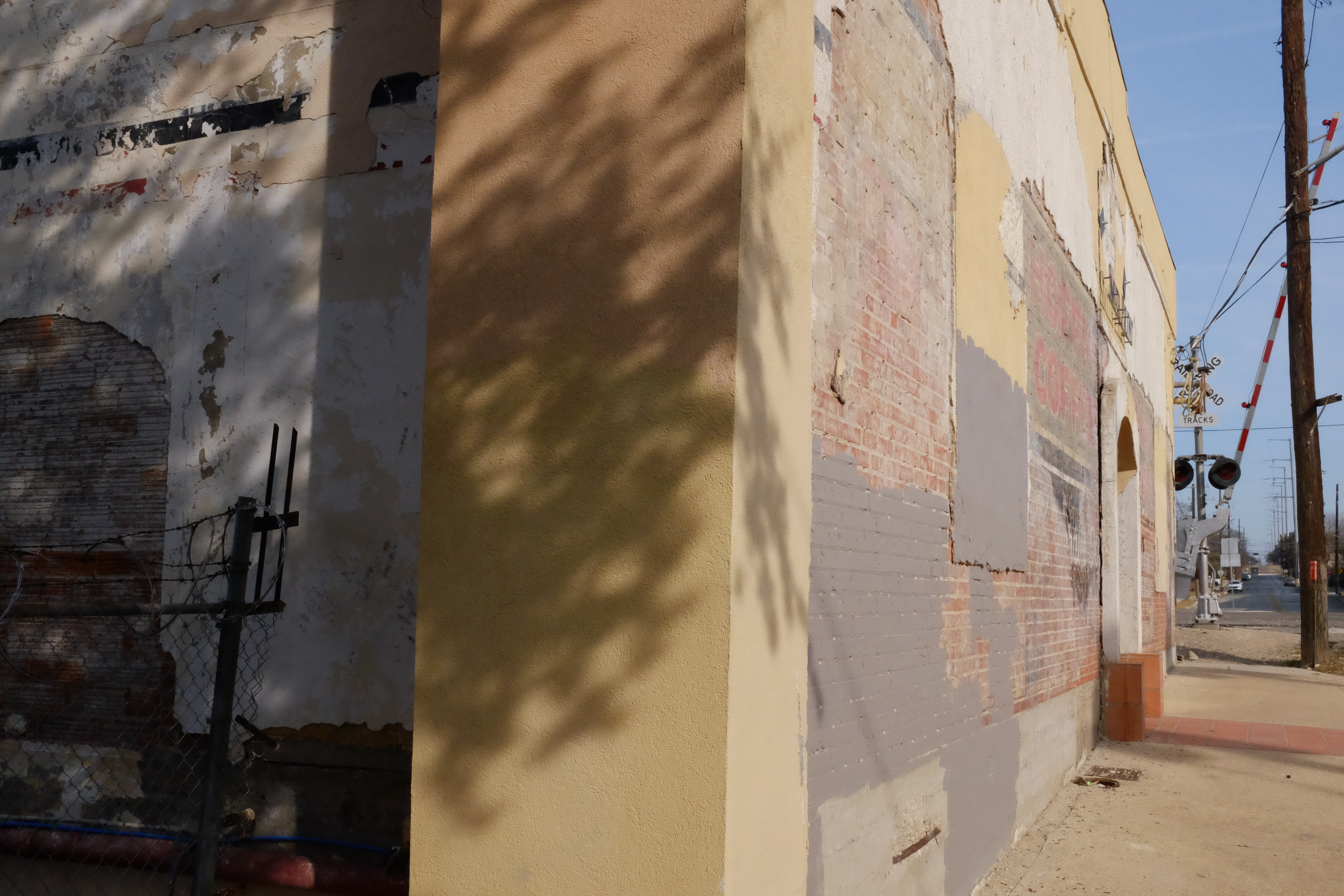 Corner — south wall toward railroad crossing; COFFEE block letters and crossing hardware