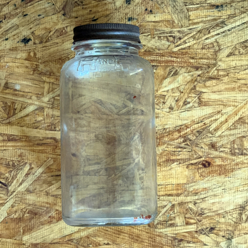 H and H one-pound smooth-body Crystalvac jar with no paper label, brown oxidized metal screw lid, and H AND H embossed in raised blocks around the shoulder, photographed 2026-07-21